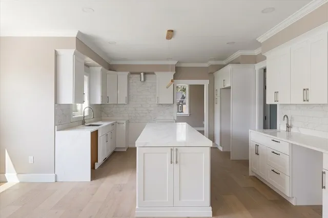 a kitchen with white cabinets and sink