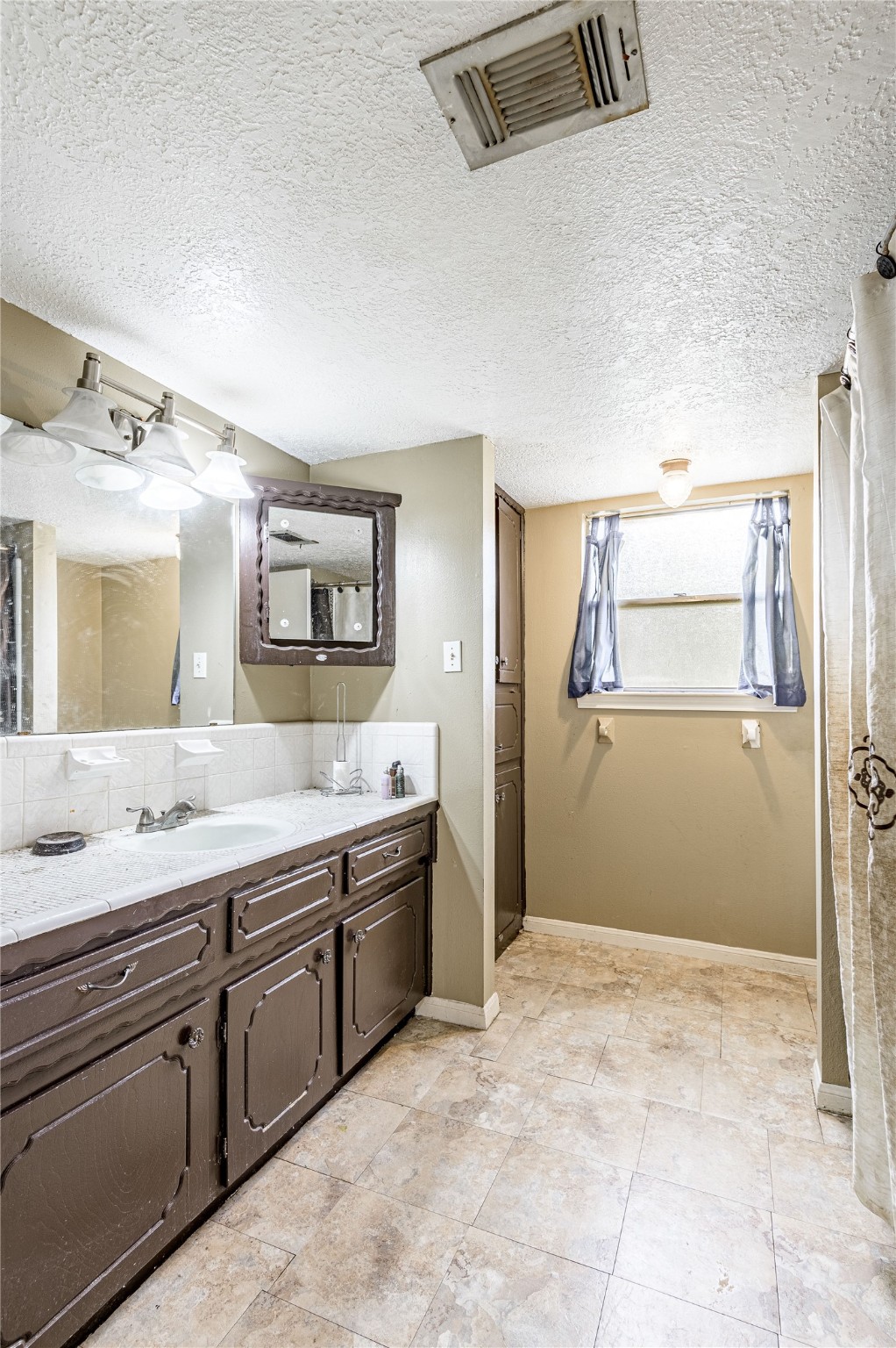7640 Highway 75 Huntsville, TX 77340 - Photo 44 of 49 a spacious bathroom with a granite countertop sink and a mirror