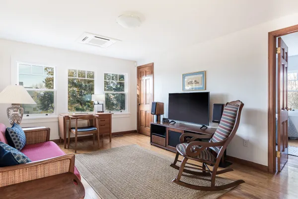 a living room with furniture a flat screen tv and a large window