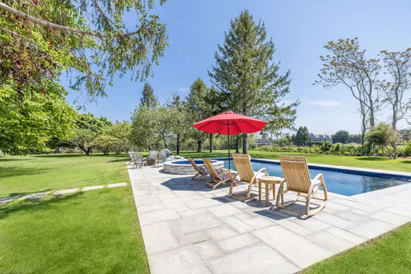 a view of a swimming pool with a table and chairs under an umbrella
