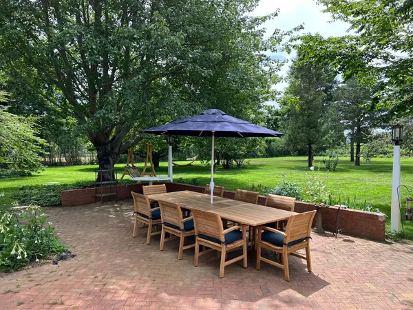 a view of patio with table and chairs under an umbrella
