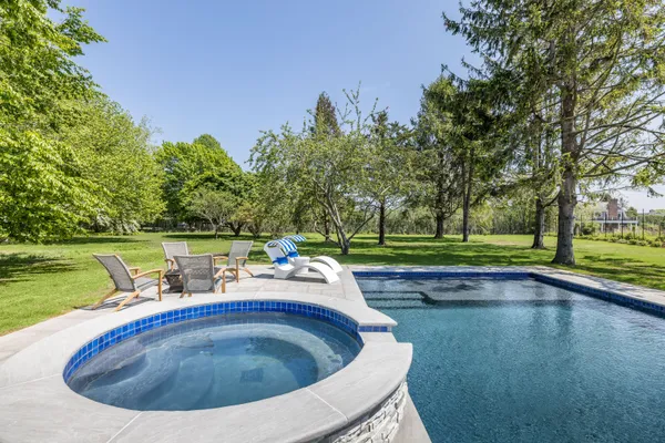 a view of a house with a yard and large trees
