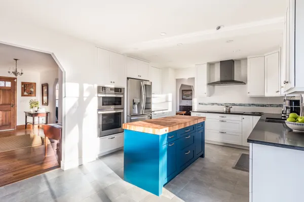 a kitchen with stainless steel appliances granite countertop a refrigerator a stove and a sink