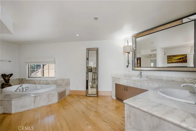 a spacious bathroom with a granite countertop sink and a bathtub