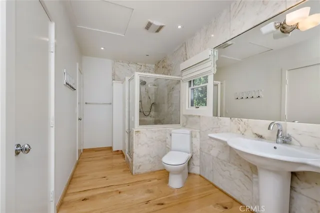a spacious bathroom with a sink a toilet a large mirror and shower