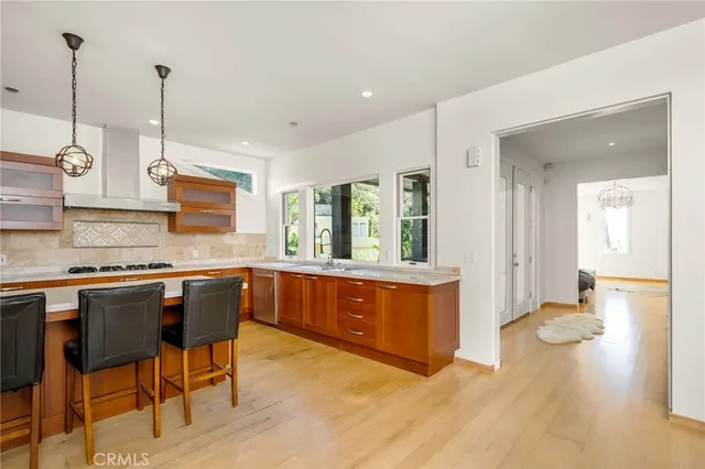 a kitchen with stainless steel appliances granite countertop a stove a sink dishwasher and a wooden cabinets with island