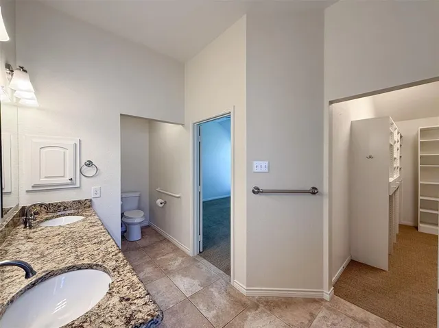 a spacious bathroom with a granite countertop sink and a mirror