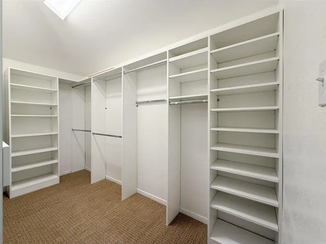 a view of walk in closet with empty racks