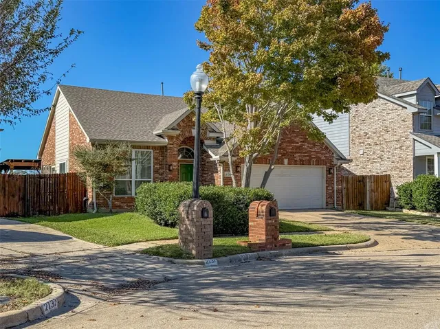 a view of a house with a yard and large tree