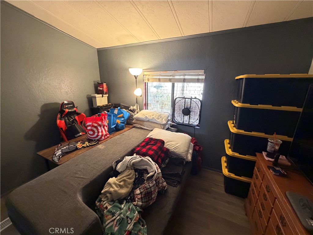 1550 Rimpau, Unit 71 Corona, CA 92881 - Photo 20 of 51 a bedroom with a bed and wooden floor