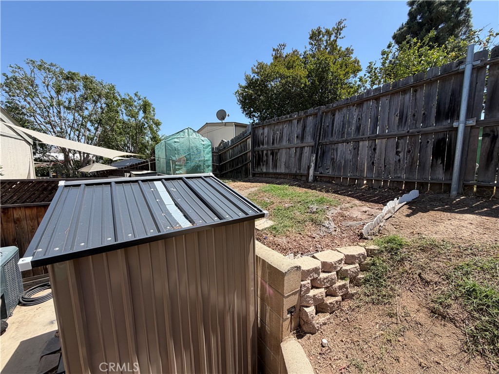 1550 Rimpau, Unit 71 Corona, CA 92881 - Photo 32 of 51 a view of backyard with wooden fence and trees in the background