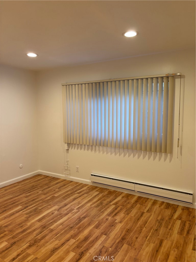 14718 Magnolia Boulevard, Unit 5 Sherman Oaks, CA 91403 - Photo 2 of 7 a view of an empty room with wooden floor and a window