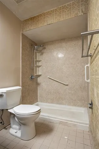 a bathroom with a toilet and a shower