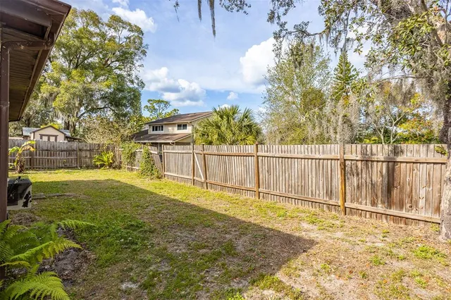 a backyard of a house with table and chairs