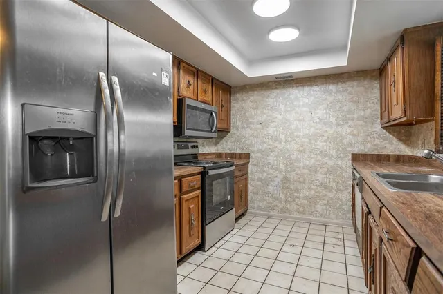 a kitchen with stainless steel appliances granite countertop a stove a refrigerator and a sink