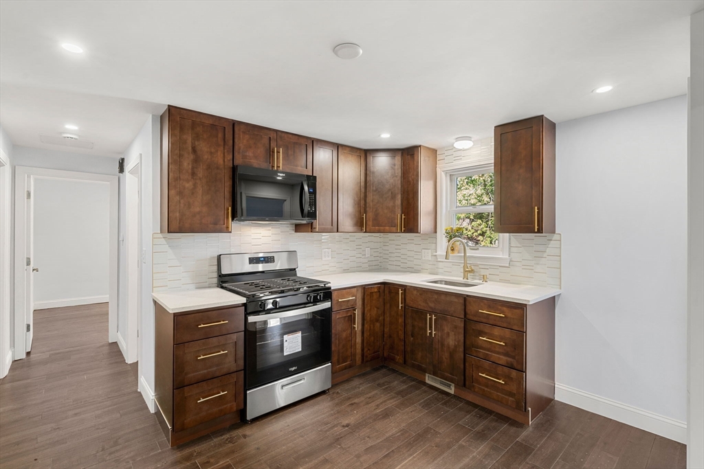 a kitchen with stainless steel appliances a stove sink and microwave