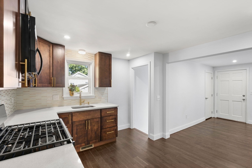 50 Bow Street Saugus, MA 01906 - Photo 14 of 37 a kitchen with kitchen island granite countertop a stove and a sink