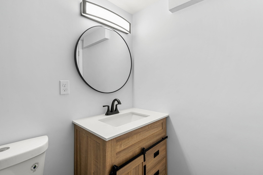 50 Bow Street Saugus, MA 01906 - Photo 22 of 37 a bathroom with a sink a mirror and a toilet