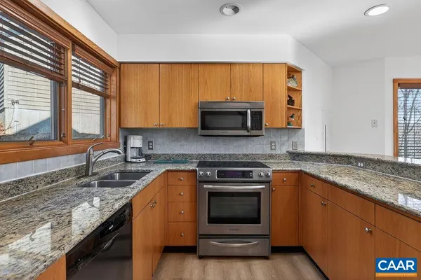 a kitchen with stainless steel appliances granite countertop a refrigerator and a sink