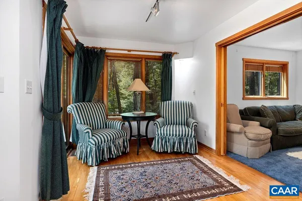 a view of a wooden chairs and a table in the balcony