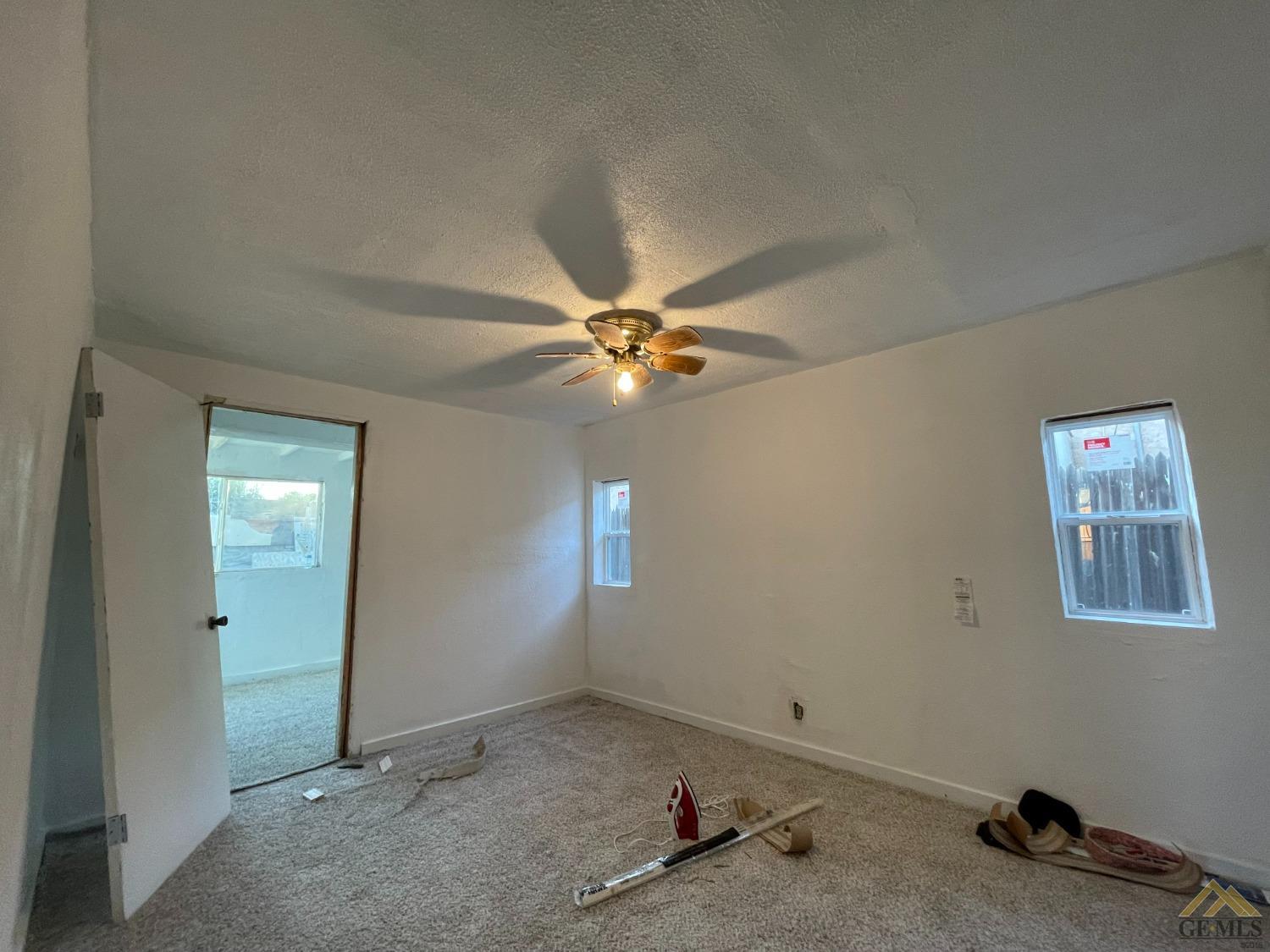 Undisclosed Address Bakersfield, CA 93308 - Photo 6 of 13 an empty room with windows and fan