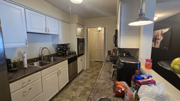 a kitchen with granite countertop a sink appliances and cabinets