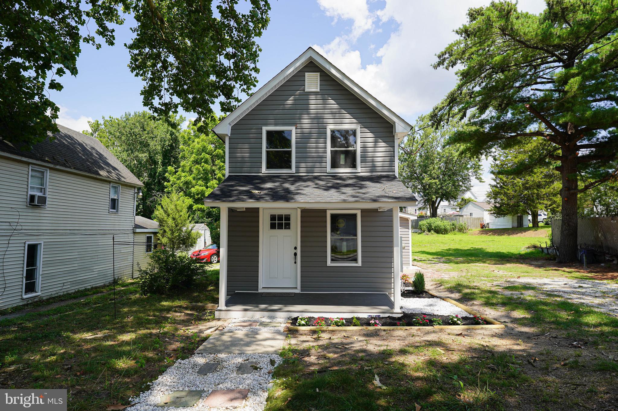 a view of a house with a yard and potted plants