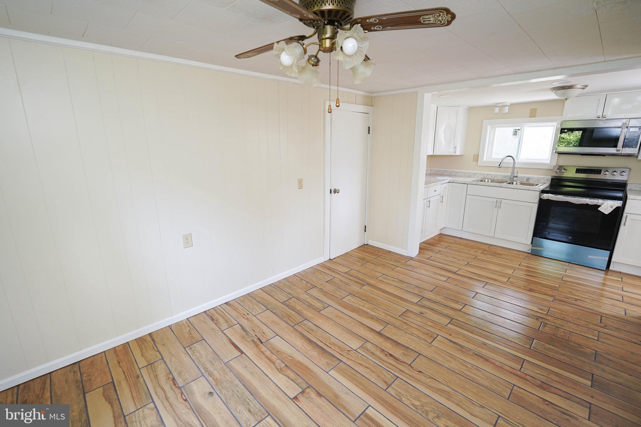 533 East 4th Street Laurel, DE 19956 - Photo 15 of 42 a kitchen with a wooden floor windows and a stove