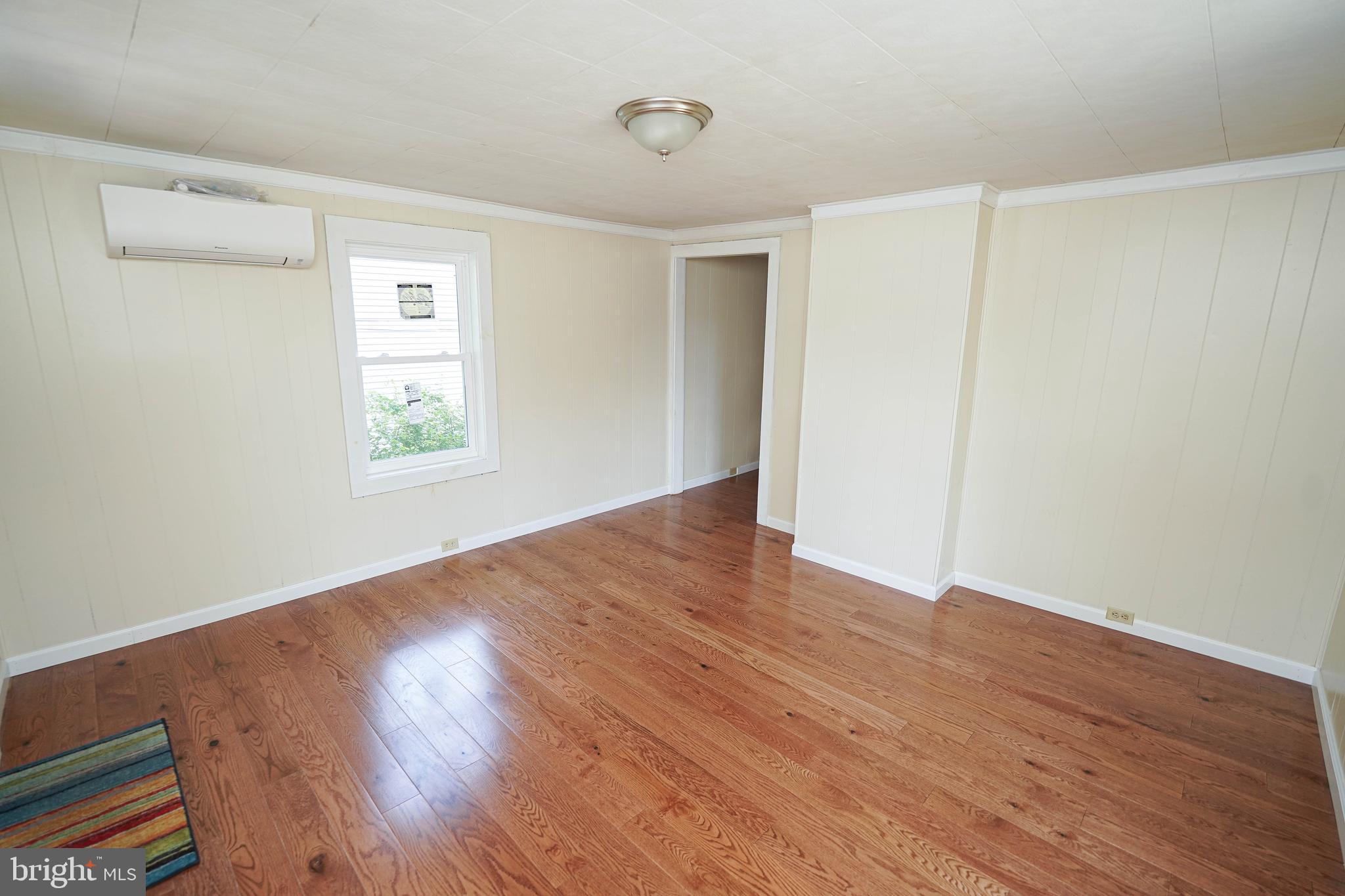 533 East 4th Street Laurel, DE 19956 - Photo 8 of 42 an empty room with wooden floor and windows