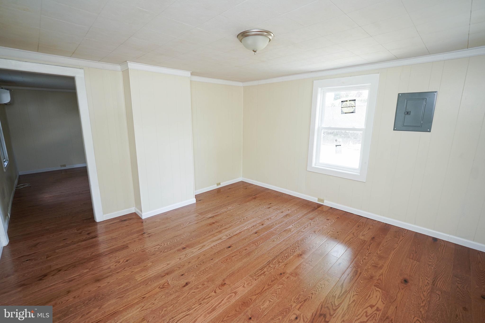 533 East 4th Street Laurel, DE 19956 - Photo 9 of 42 an empty room with wooden floor and windows