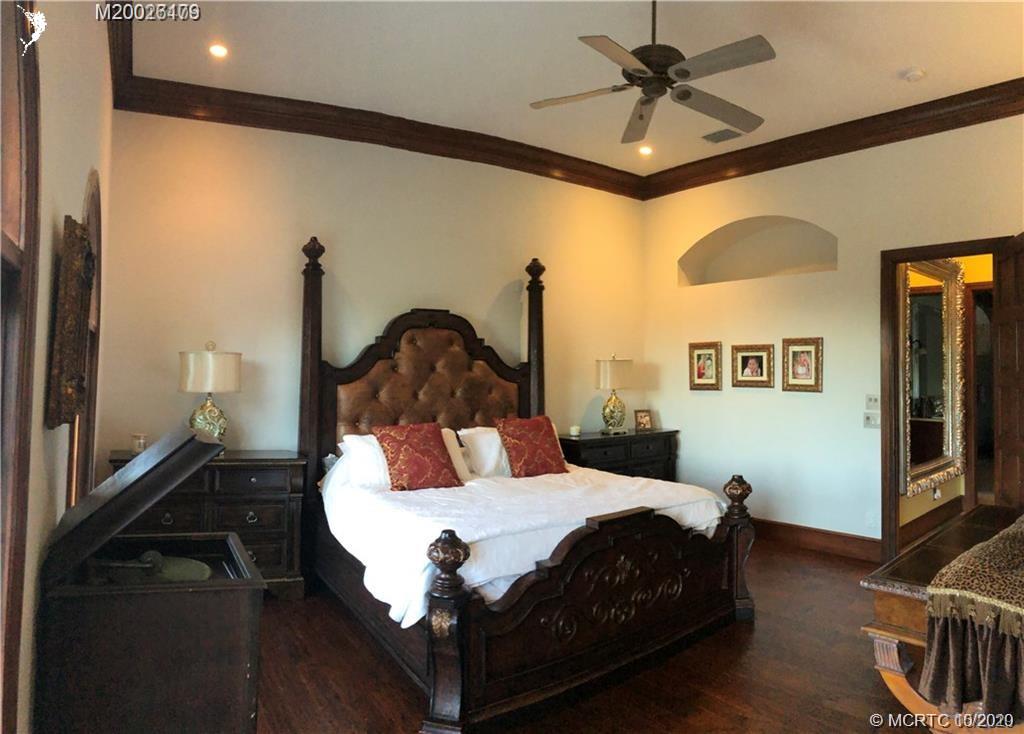 15 Middle Road Stuart, FL 34996 - Photo 10 of 28 a bedroom with a bed and a chandelier