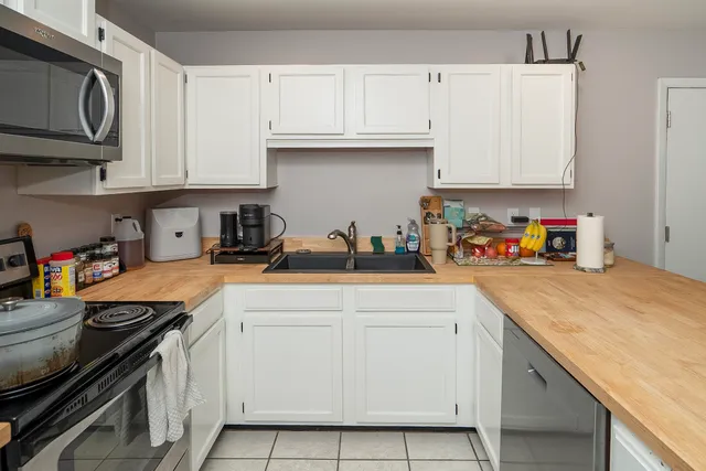 a kitchen with stainless steel appliances granite countertop a sink stove and cabinets