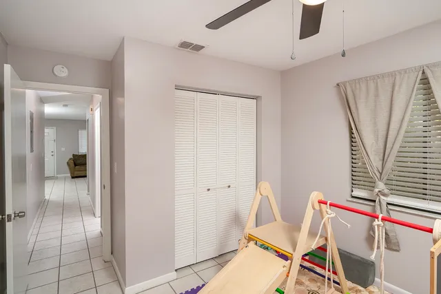 a living room with a dining table and a ceiling fan
