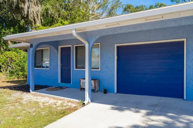 a view of house with outdoor space and trees in the background