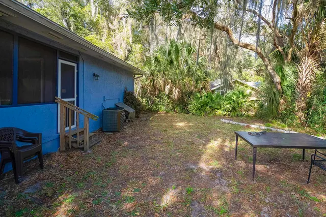 a backyard of a house with barbeque oven table and chairs