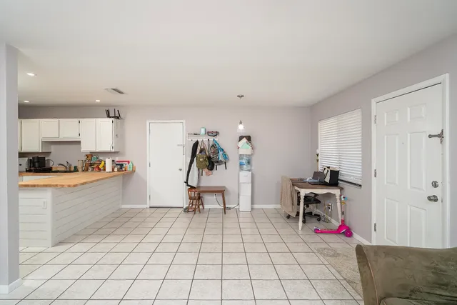 a living room with furniture and a dining table with kitchen view