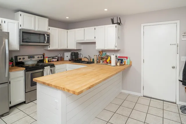 a kitchen with stainless steel appliances a sink a stove a microwave and cabinets