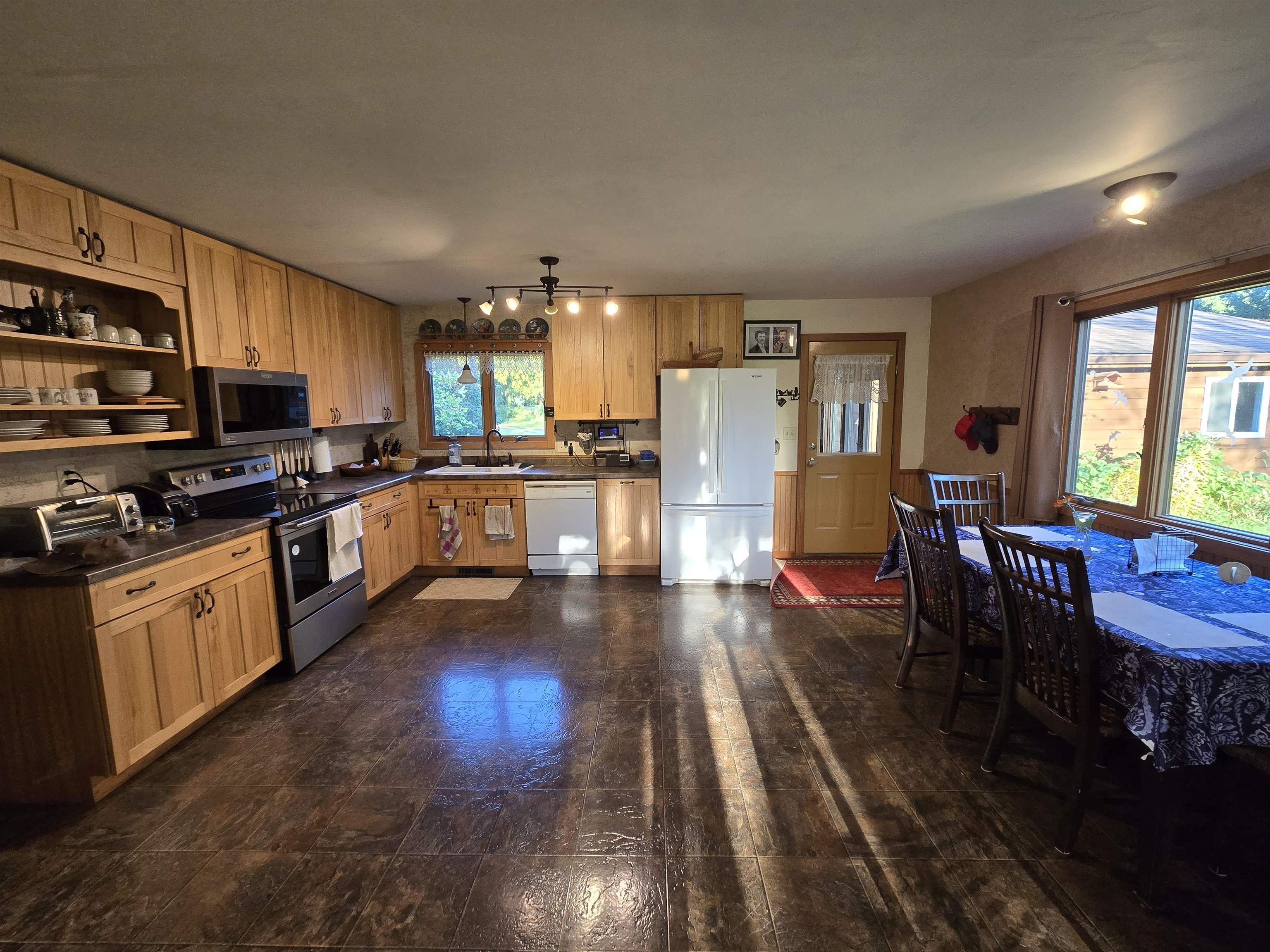 17065 Highway 64 Polo, IL 61064 - Photo 15 of 26 a kitchen with stainless steel appliances granite countertop a stove refrigerator and a dining table with wooden floor