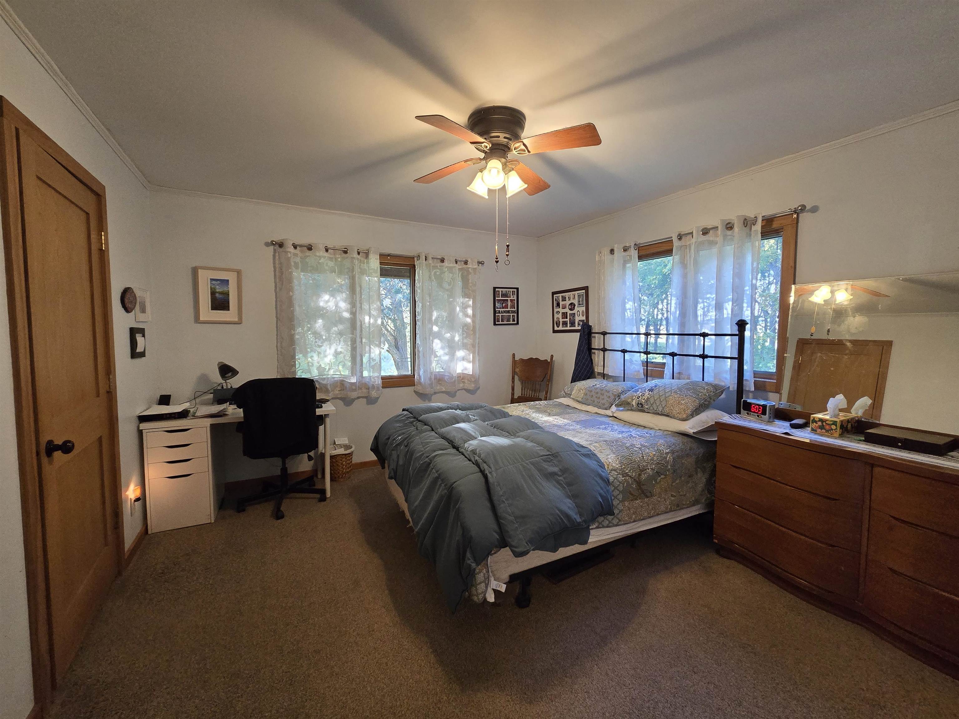 17065 Highway 64 Polo, IL 61064 - Photo 18 of 26 a spacious bedroom with a bed and a chandelier