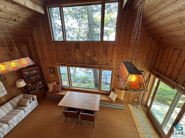 2763 Van Vac Road Ely, MN 55731 - Photo 26 of 37 Vaulted wood-paneled interior featuring a large window array, built-in window seating, and a prominent stained-glass chandelier