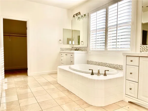 a white bath tub sitting in a bathroom next to a window