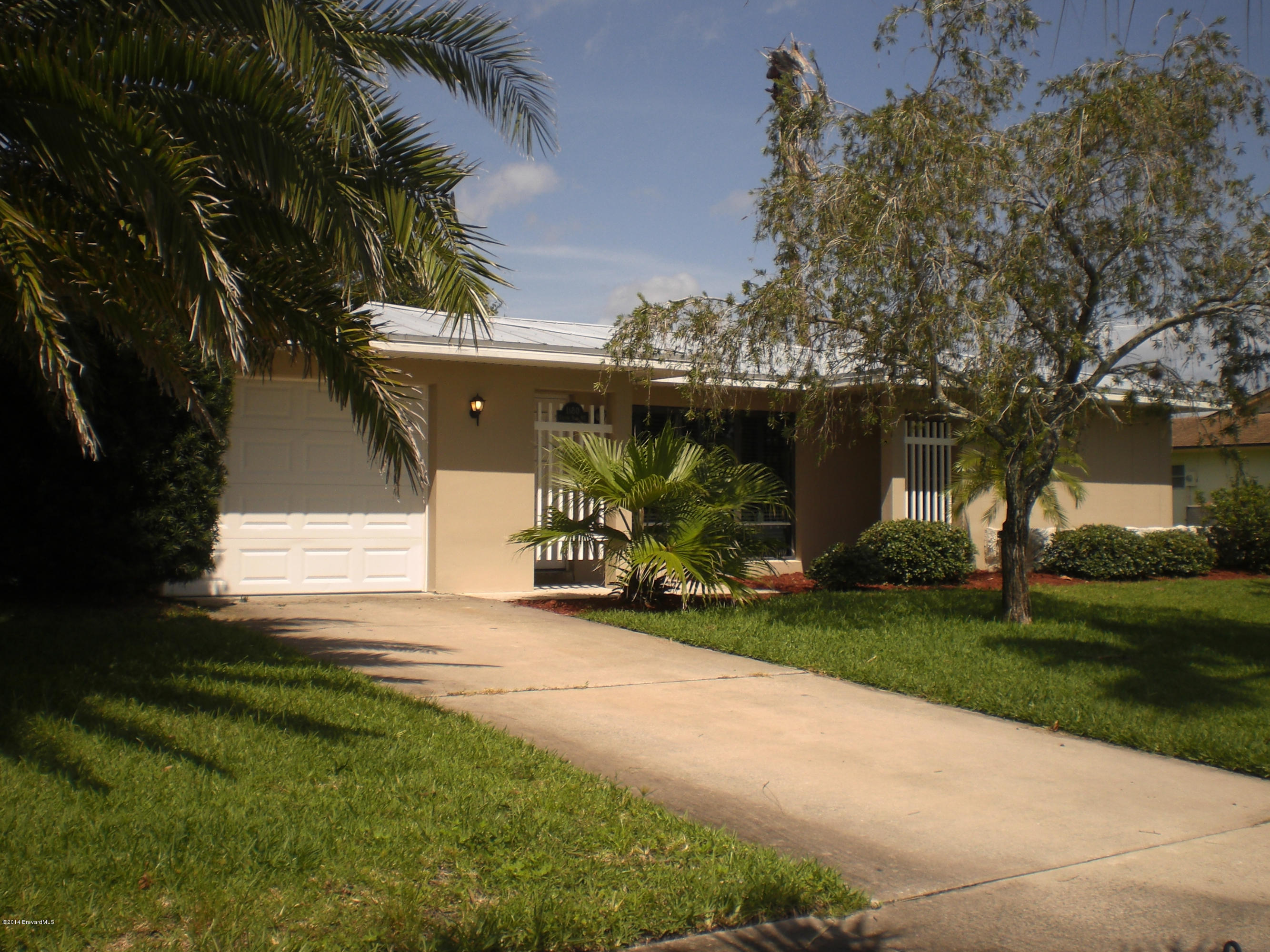 1180 Cotton Road Northeast Palm Bay, FL 32905 - Photo 2 of 18 a view of a house with backyard and a tree