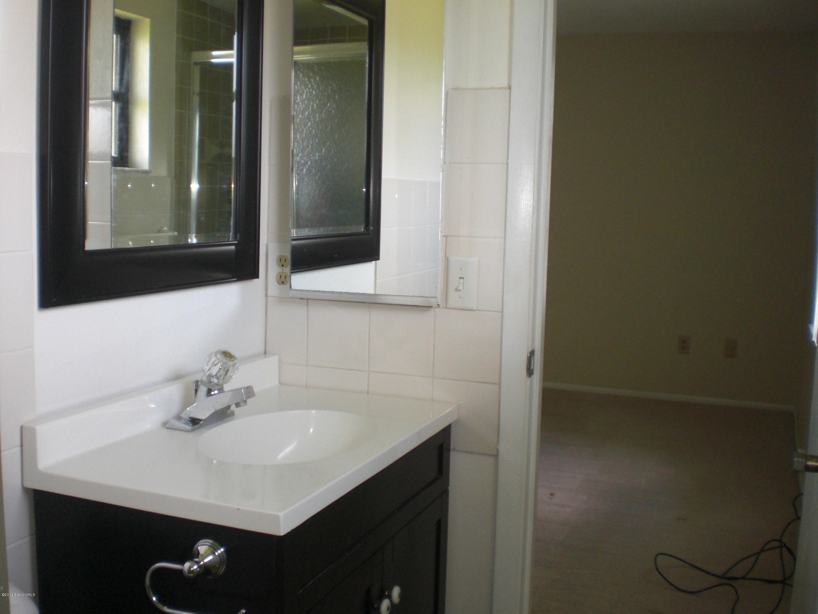 1180 Cotton Road Northeast Palm Bay, FL 32905 - Photo 11 of 18 a bathroom with a sink and a mirror