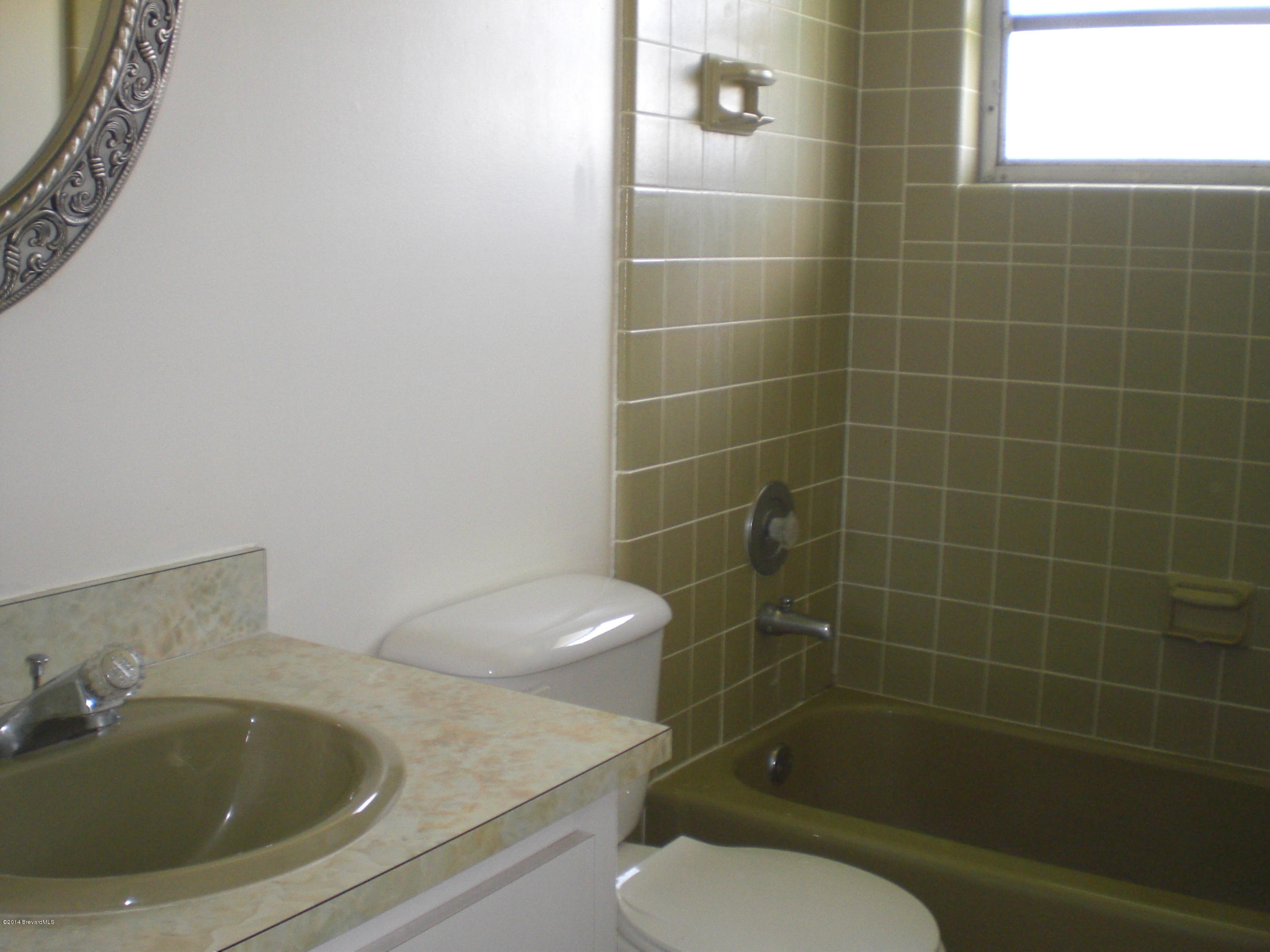 1180 Cotton Road Northeast Palm Bay, FL 32905 - Photo 13 of 18 a bathroom with a sink toilet and shower