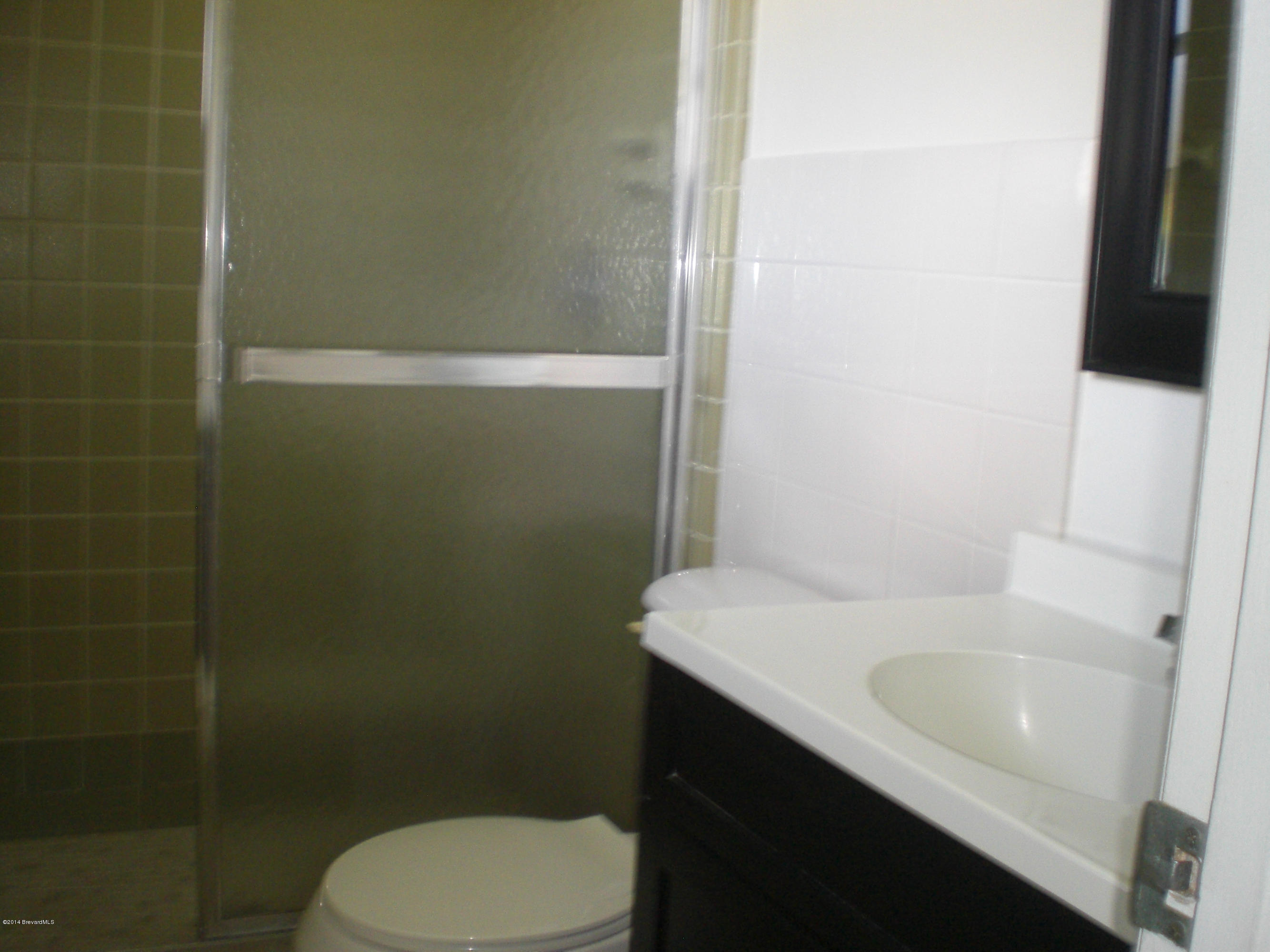 1180 Cotton Road Northeast Palm Bay, FL 32905 - Photo 10 of 18 a bathroom with a sink a toilet and shower