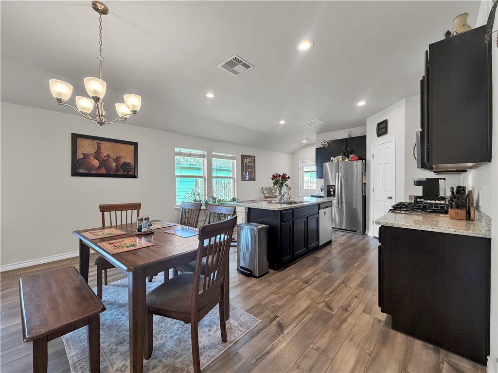 2301 Soothing Street Corpus Christi, TX 78418 - Photo 8 of 25 a view of a dining room with furniture a chandelier and wooden floor