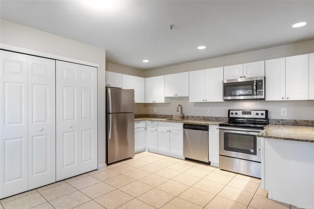a kitchen with stainless steel appliances granite countertop a refrigerator and a stove top oven