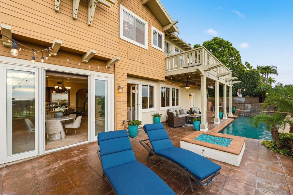 1375 Ravean Court Encinitas, CA 92024 - Photo 25 of 75 a view of a patio with couches table and chairs under an umbrella