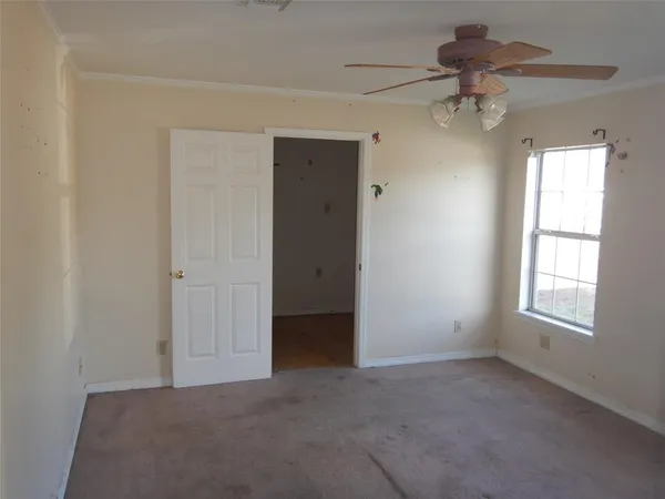 an empty room with windows and fan