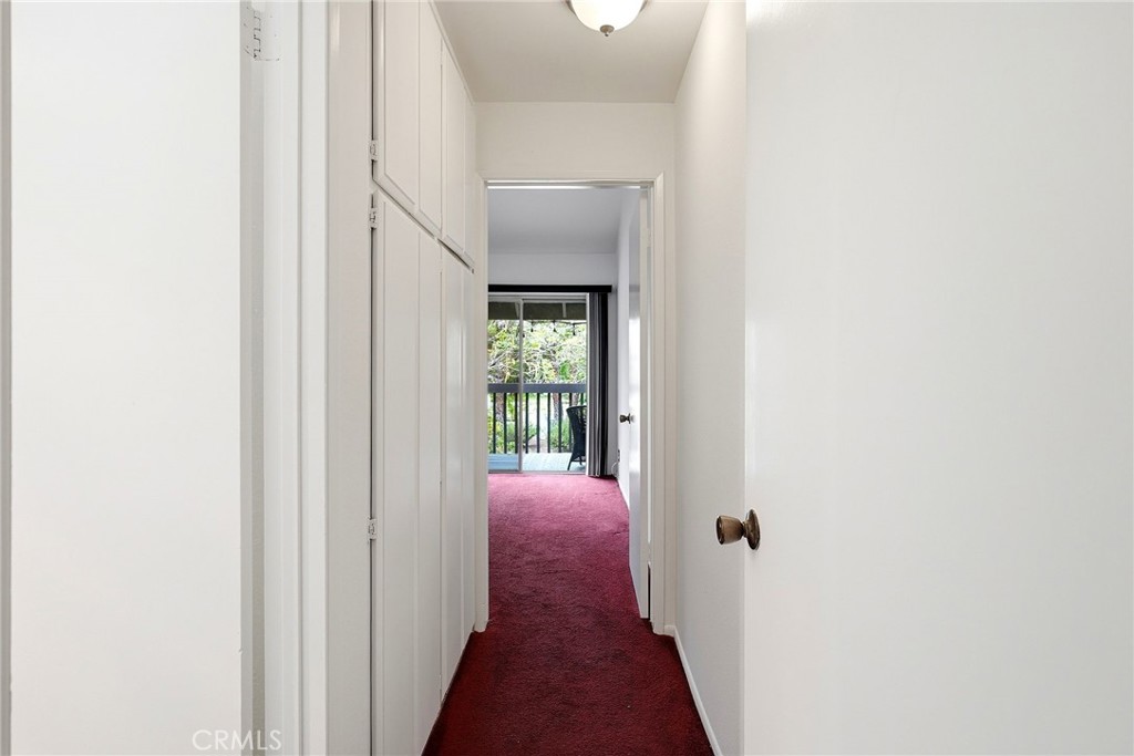 7890 East Spring Street, Unit 11E Long Beach, CA 90815 - Photo 25 of 40 a view of a hallway with wooden floor and a bathroom
